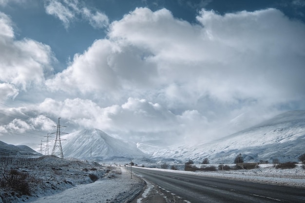 写真 スコットランドの高地と雪に覆われた山々を通る冬の道スコットランドイギリス