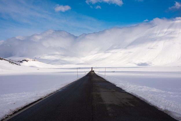 Winter road in a valley surrounded by mountains covered with snow