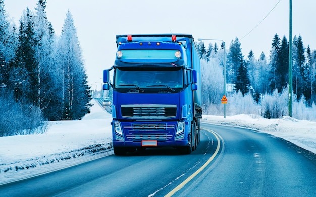 雪のある冬の道。フィンランドのトラック。ラップランドの大型トラックと寒い風景。ヨーロッパの森。フィンランドの都市高速道路に乗る。道路とルートの雪に覆われたストリートトリップ。下り坂の私道での配達