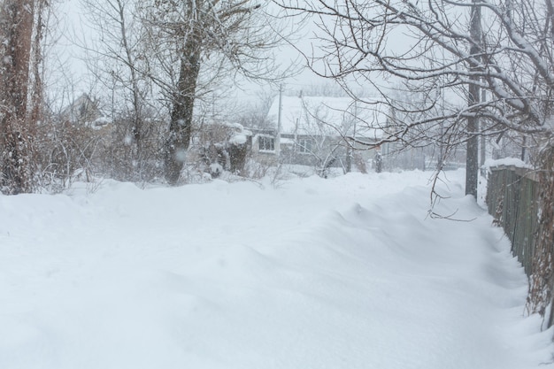 Winter, rural streets are covered with snow. Snow blizzard