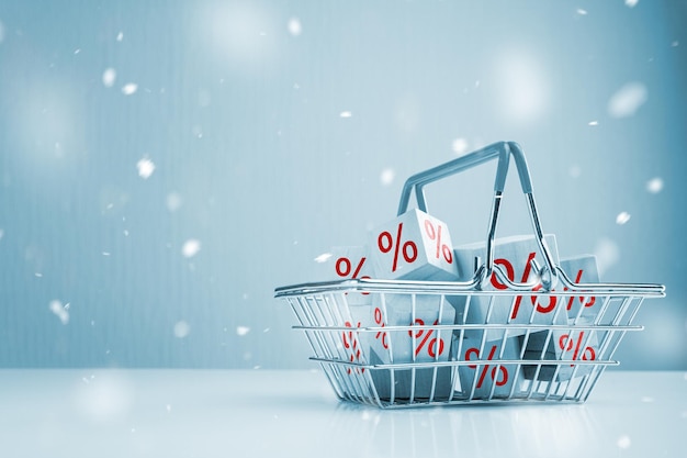 Winter Sale Shopping basket and boxes with sign discount percent Shopping cart and red percentage sign and snow effect background Christmas and New year sale concept