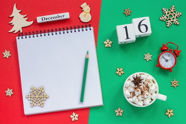 Winter samenstelling. Houten kalender 16 december Kopje cacao met marshmallow, lege open Kladblok met potlood