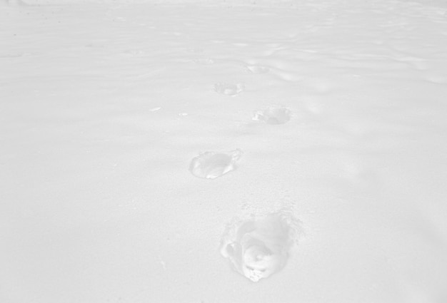 winter and season concept - footprints on snow surface