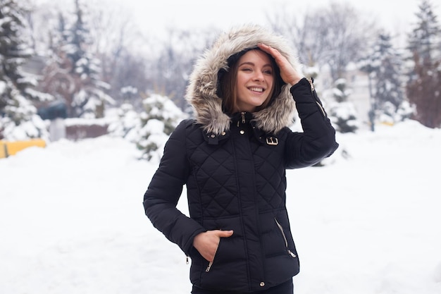 Winter season and young attractive woman in the forest