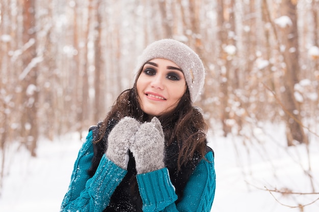 Winter, seizoen en mensen concept - portret van jonge mooie vrouw wandelen in besneeuwde park