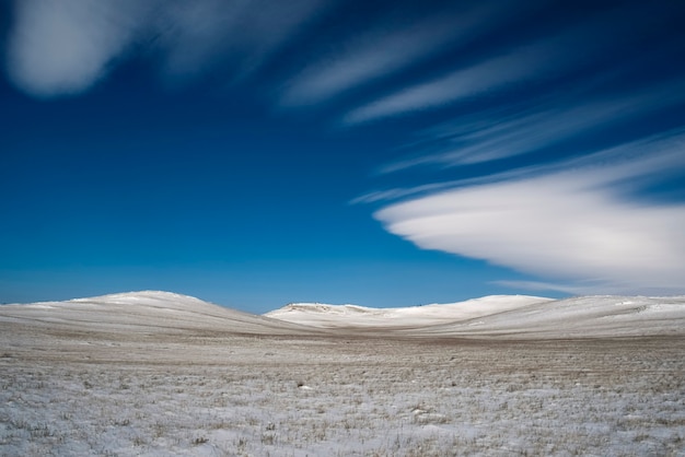 Foto paesaggio invernale innevato con nuvole lenticolari, cielo blu. sfondo del desktop regione di irkutsk, russia