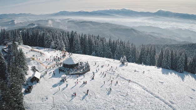 Photo winter sport resort at snow mountain top aerial people at nature landscape ski slope at fir forest