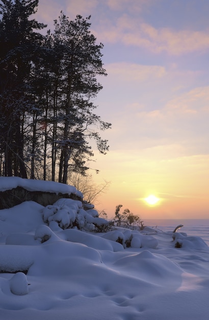 雪に覆われた海岸の冬の夕日