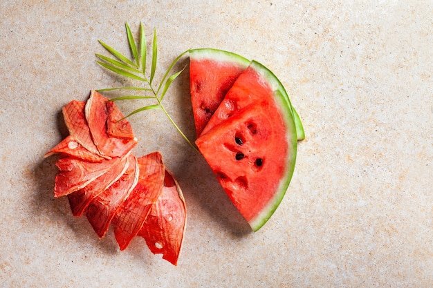 Winter supplies: slices of dried watermelon with fresh pieces on light background.