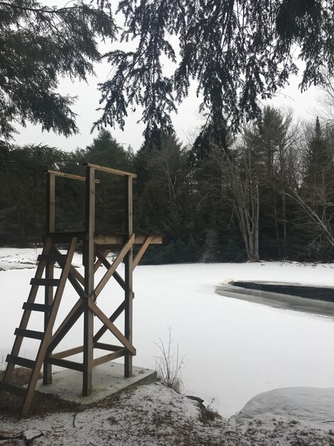 Winter at the swimming hole ice covered river with the wooden diving platform at the riverside