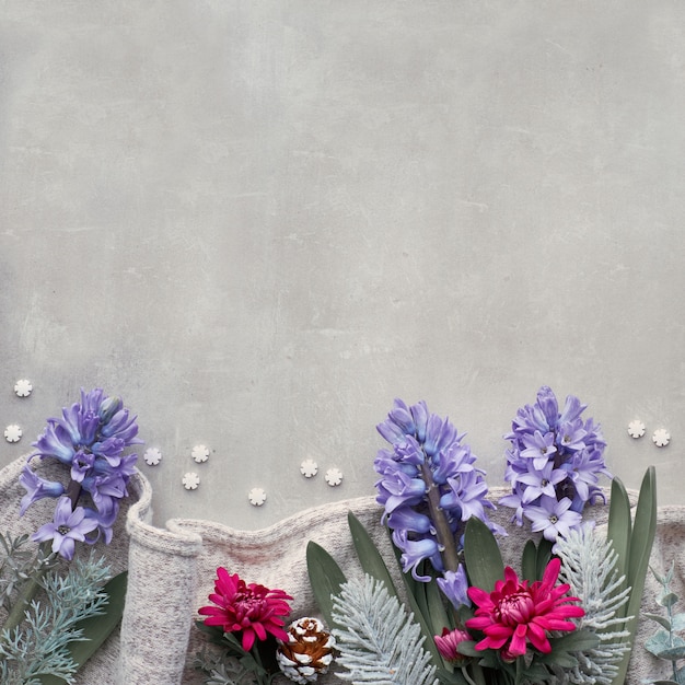 Winter table with seasonal flowers   blue hyacinth and burgundy chrysanthemum, square composition, top view with copy space