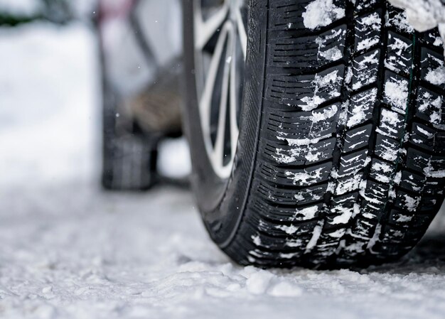 Foto pneumatico invernale dettaglio di pneumatici per auto in inverno sulla strada coperta di neve
