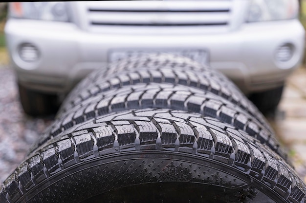 Winter tires with spikes on the background of a car closeup safety during winter