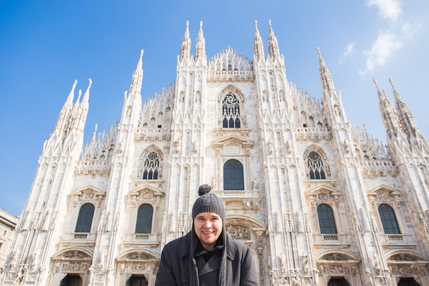 Winter travel, vacations and people concept - Handsome male tourist making selfie photo in front of the famous Duomo cathedral in Milan.