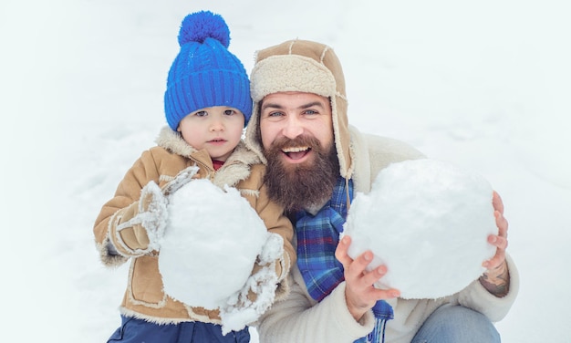 Winter vader en zoon spelen buiten vader en zoon maken sneeuwbal op winter witte achtergrond