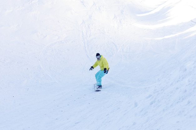 Winter, vrije tijd, sport en mensen concept - actieve snowboarder springen in de bergen op een zonnige dag. Snowboarden close-up. Skigebied Sheregesh