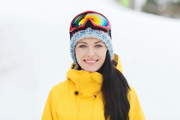 winter, vrije tijd, sport en mensen concept - gelukkige jonge vrouw in skibril buitenshuis