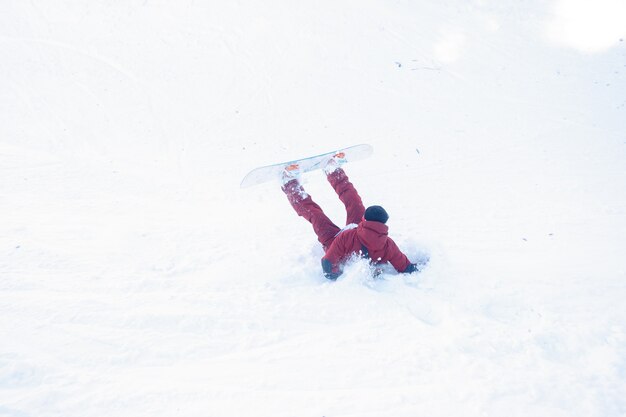 Winter, vrije tijd, sport en mensen concept - Snowboarder crashte in de sneeuw. Snowboarder valt op verse sneeuw