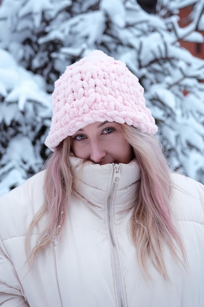 Winter vrouw in de sneeuw camera kijken buiten op sneeuwt koude winterdag Portret Kaukasisch vrouwelijk model buiten in de eerste sneeuw