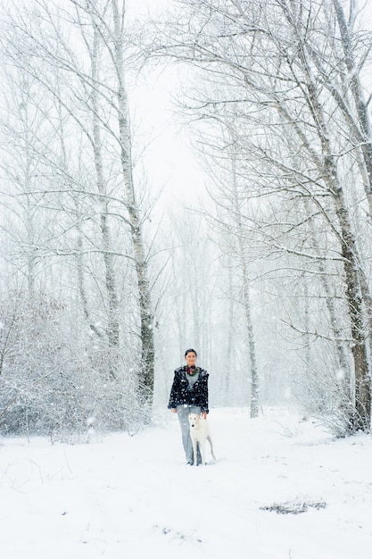 Winter walk in a snowstorm with a dog