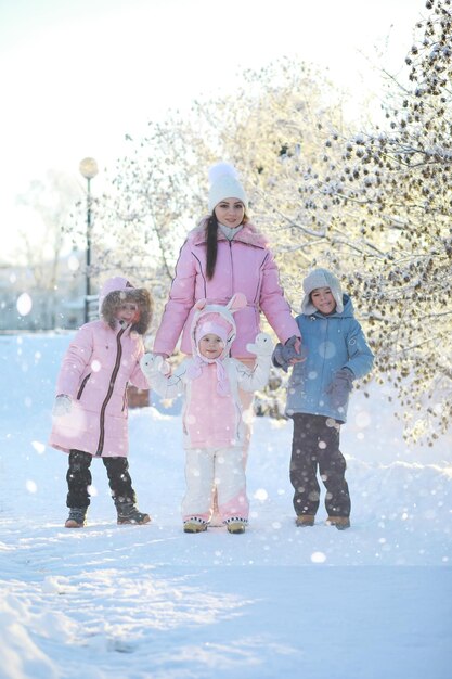 Winter walk on the street on a sunny frosty day family with
children play snowballs in the park winter holidays and family
vacation