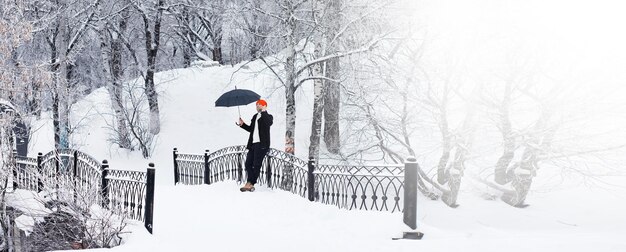 Winter walk with an umbrella.Man in a coat with an umbrella, walk against the backdrop of the winter landscape, winter view