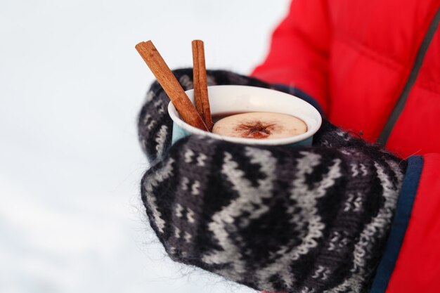 Winter warme drank in het bos, glühwein in handen