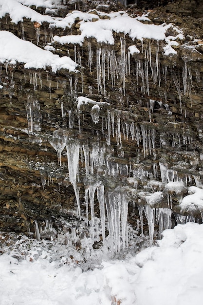 Winter waterfall with icicles on the small river at the forest Beautiful winter landscape