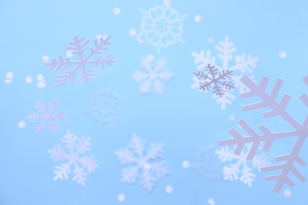 Winter . White snowflakes cut from white paper on a blue background.