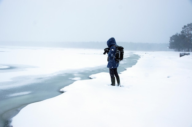 Foto winter wit landschap van bevroren baai met gesmolten ijs, fotograaf staat aan de rand van de kust.