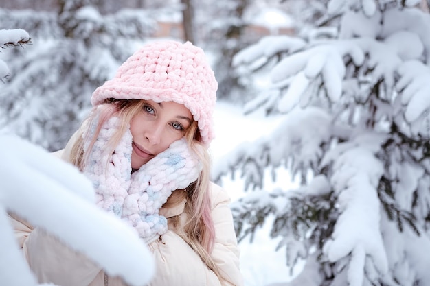 Winter woman in snow looking at camera outside on snowing cold winter day Portrait Caucasian female model outside in first snow