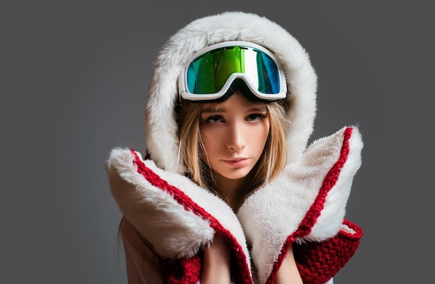 スタジオ スノーボード女性スノーボーダーのポートレートでポーズをとる雪のゴーグルを持つ冬の女性