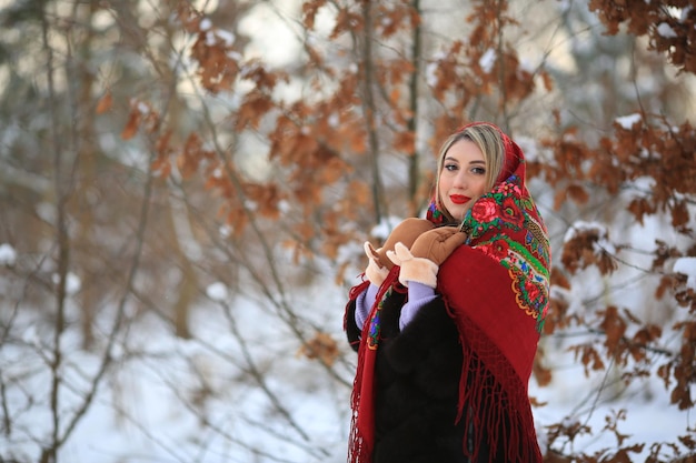 冬の女性の暖かい服 黒い毛皮のコート 雪の中で金髪の笑顔