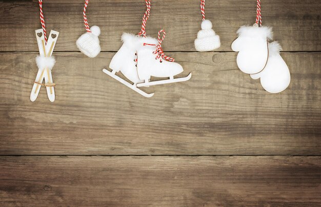 Winter wooden backdrop with hanging skis skates mittens and hats