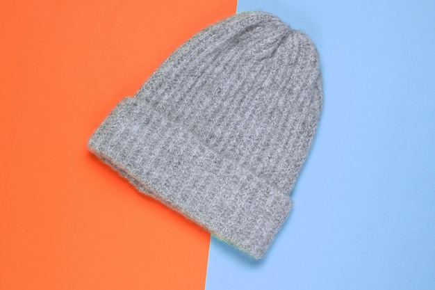 Winter woolen hat on a colored paper background