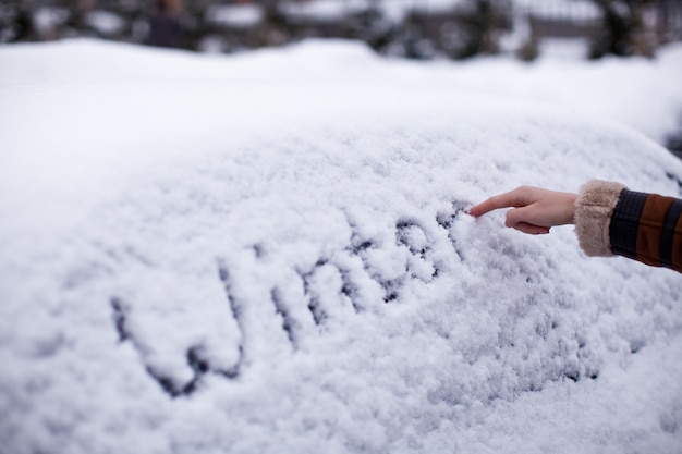 Winter written in snow on car