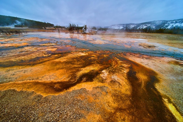 Winter at yellowstone basin with pools of alkaline water making\
colorful waves