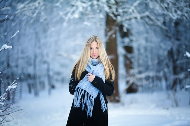 Winter. Young girl walking snowy forest and smiling . Great mood.