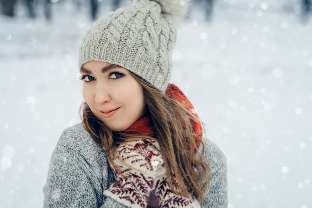 Inverno giovane donna ritratto bellezza ragazza gioiosa che ride e si diverte nel parco invernale