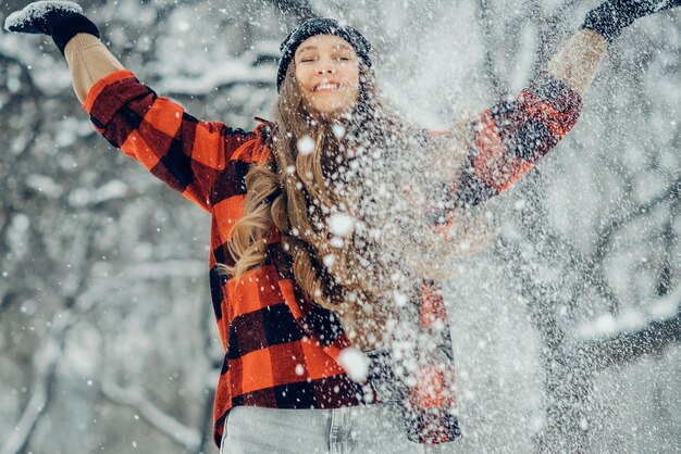 写真 冬の若い女性の肖像画 美しさ 喜びのモデル少女 冬の公園で笑って楽しんでいます