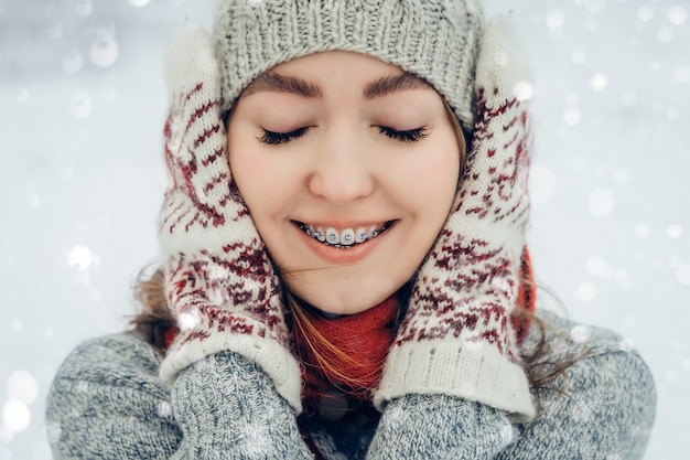 冬の若い女性の肖像画。笑って、冬の公園で楽しんでうれしそうな美少女モデル。美しい若い女性屋外、自然を楽しんで、冬