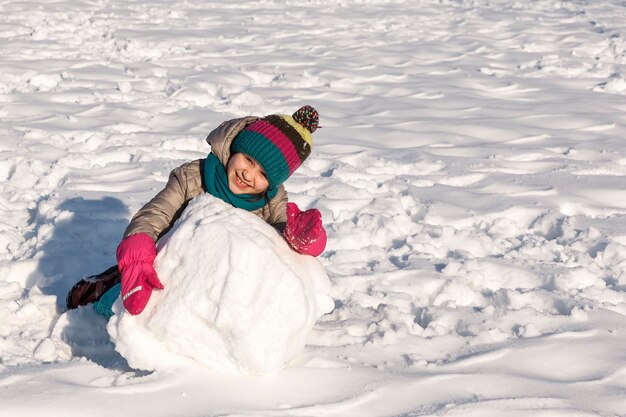 Winteractiviteit wandelende kinderen spelen in het sneeuwpark kind maken sneeuwpop joufull jeugd