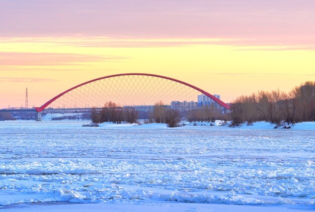 Winteravond op de Ob. Ijsheuvels op de rivier, de boog Bugrinskij brug vdaleke