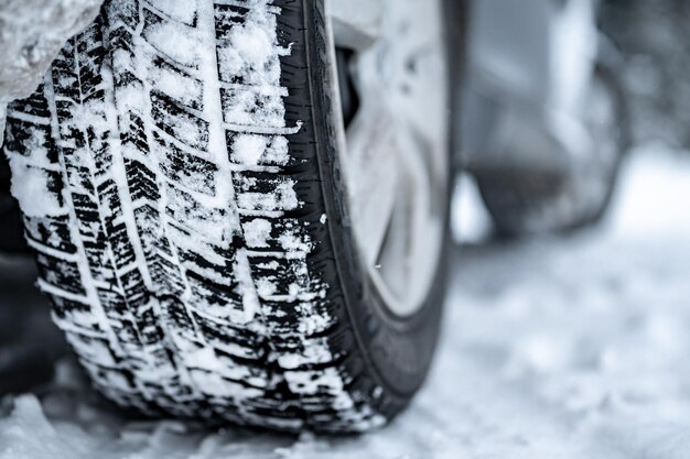 Winterband Detail van autobanden in de winter op de weg bedekt met sneeuw