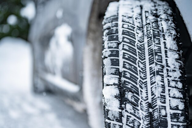 Winterband Detail van autobanden in de winter op de weg bedekt met sneeuw