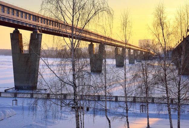 Winterdijk in de avond De grootste metrobrug ter wereld over de rivier de Ob Novosibirsk