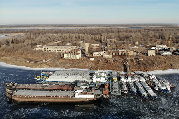 Wintering ships on a frozen river. There are many ships at the pier. Volgograd. Russia.