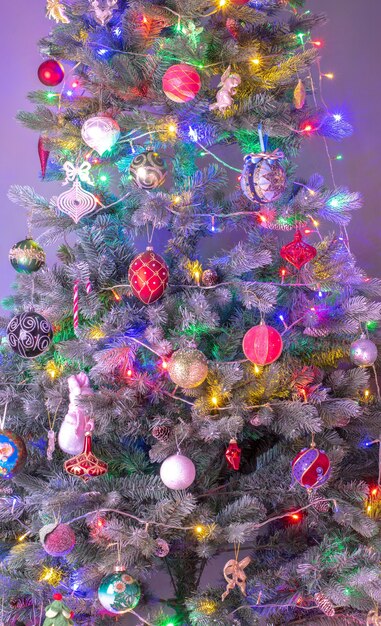 Winterkerstachtergrond: kerstboom versierd met sprankelende ballen en kegels
