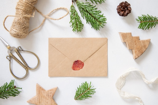 Winterkerstcompositie met een kaart over verzegelde envelop platliggend mockup