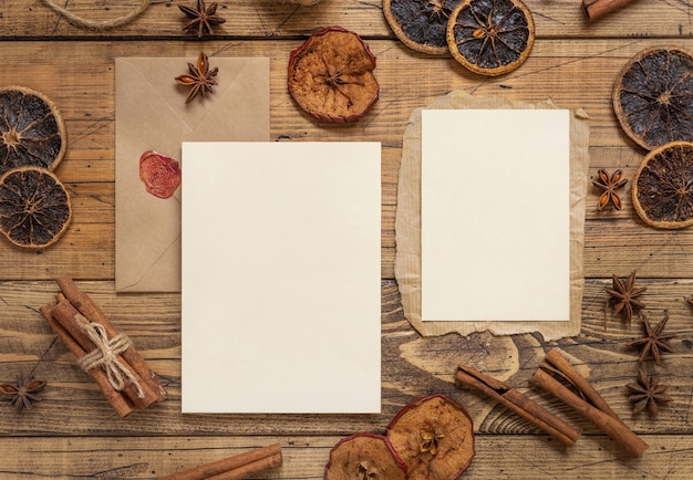 Winterkerstsamenstelling met blanco kaarten en envelop over houten tafel plat gelegd